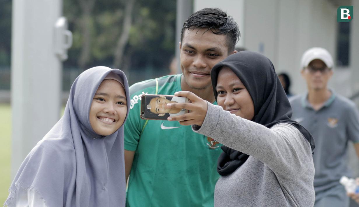 Bek Timnas Indonesia, Rachmat Irianto, foto bersama fans usai latihan di Lapangan ABC Senayan, Jakarta, Kamis (22/2/2018). Latihan ini dilakukan untuk persiapan Piala AFF U-18 2018 dan Piala Asia U-19 2018. (Bola.com/M Iqbal Ichsan)