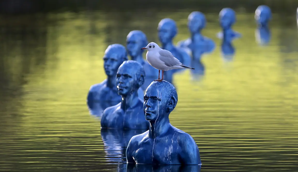 Seekor burung berdiri diatas patung karya seniman Argentina Pedro Marzorati di taman Montsouris, Perancis, (26/11). Instalasi seni ini dipasang untuk menjelang KTT Iklim COP21 di Paris. (REUTERS/Christian Hartmann)