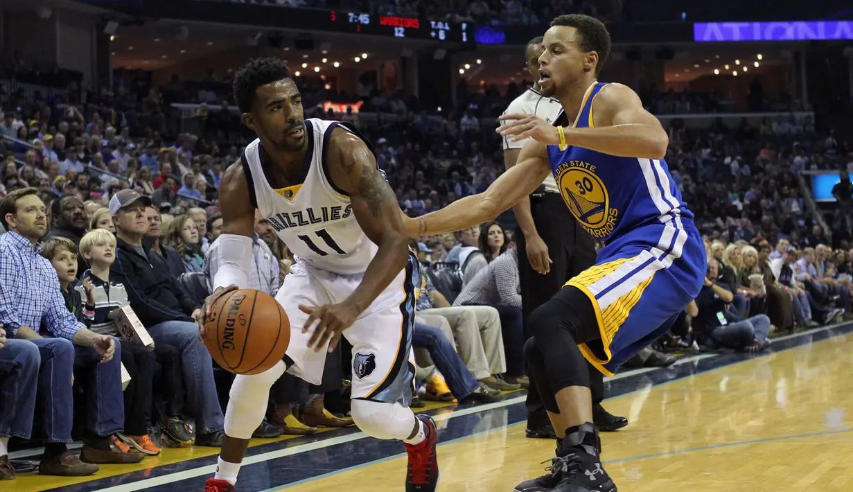 Pebasket Memphis Mike Conley (kiri) menggiring bola melewati pebasket  Warriors Stephen Curry Pada Lanjutan NBA di FedExForum, Memphis,Kamis (12/11/2015).. Golden State kalahkan Memphis 100-84. (Reuters/Nelson Chenault-USA TODAY Sports)
