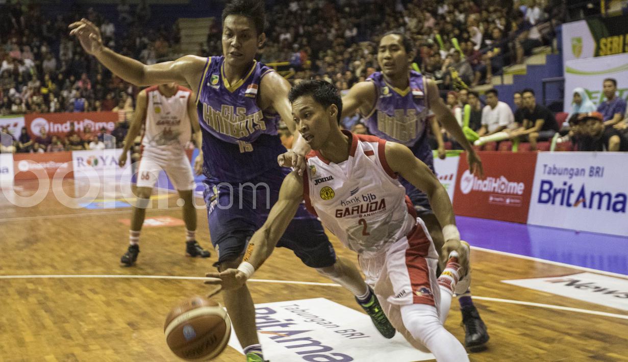 Pebasket Garuda Bandung, Januar Kuntara, berusaha lepas dari kawalan pemain CLS Knights pada laga IBL Regular Season 2017 di C-tra Arena Bandung, Jawa Barat, Minggu (26/2/2017). Garuda kalah 54-57 atas CLS. (Bola.com/Vitalis Yogi Trisna)