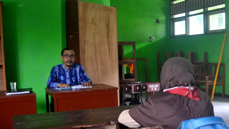 Guru penghayat kepercayaan dan siswa melakukan kegiatan belajar mengajar di ruang OSIS sebuah SMP Negeri di Gandrungmangu. (Foto: Liputan6.com/Muhamad Ridlo)