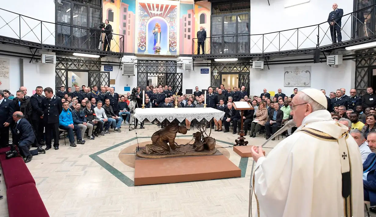 Paus Fransiskus memimpin misa selama kunjungannya ke pusat penahanan Regina Coeli di Roma, Italia, Kamis (29/3). Paus mengunjungi sebuah penjara pada Kamis Putih untuk mencuci kaki sejumlah narapidana. (Vatican Media via AP)