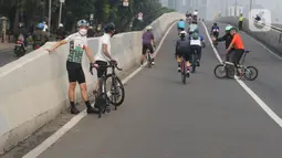 Sejumlah pengguna sepeda road bike melintas di Jalan Layang Non Tol (JLNT) Kampung Melayu-Tanah Abang, Jakarta, Minggu (30/5/2021). Dinas Perhubungan DKI Jakarta melakukan uji coba lintasan road bike JLNT Kampung Melayu-Tanah Abang tahap kedua pada pukul 05.00-08.00 WIB. (Liputan6.com/Herman Zakhari