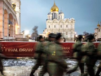 Sejumlah petugas keamanan melintas di depan lokasi drawing Piala Dunia 2018 di Kremlin, Moscow, Kamis (30/11/2017). Drawing 32 peserta Piala Dunia 2018 akan dilakukan pada Jumat (1/12/2017) di Rusia. (AFP/Mladen Antonov)