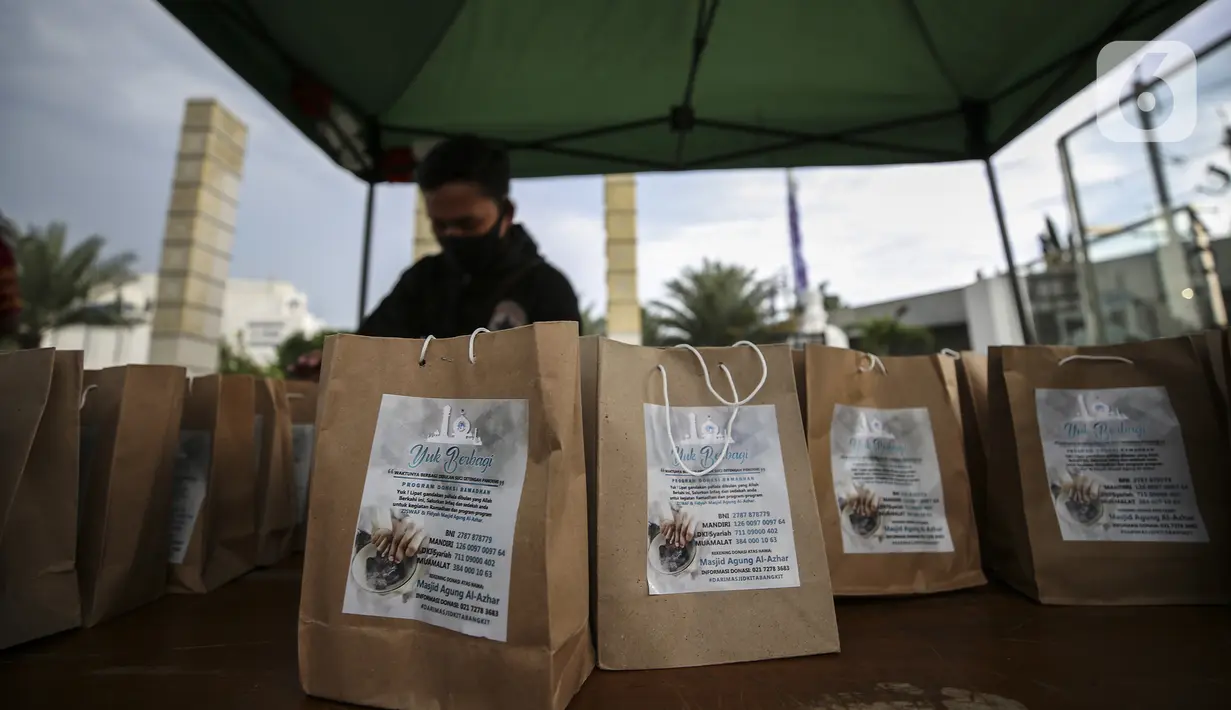 Petugas menyiapkan takjil untuk dibagikan kepada pengendara di Kompleks Masjid Al-Azhar, Jakarta, Kamis (15/4/2021). Pengelola masjid menyiapkan 500 bungkus takjil setiap harinya untuk pengendara yang dibagikan dengan sistem drive thru untuk mencegah penyebaran COVID-19. (Liputan6.com/Johan Tallo)