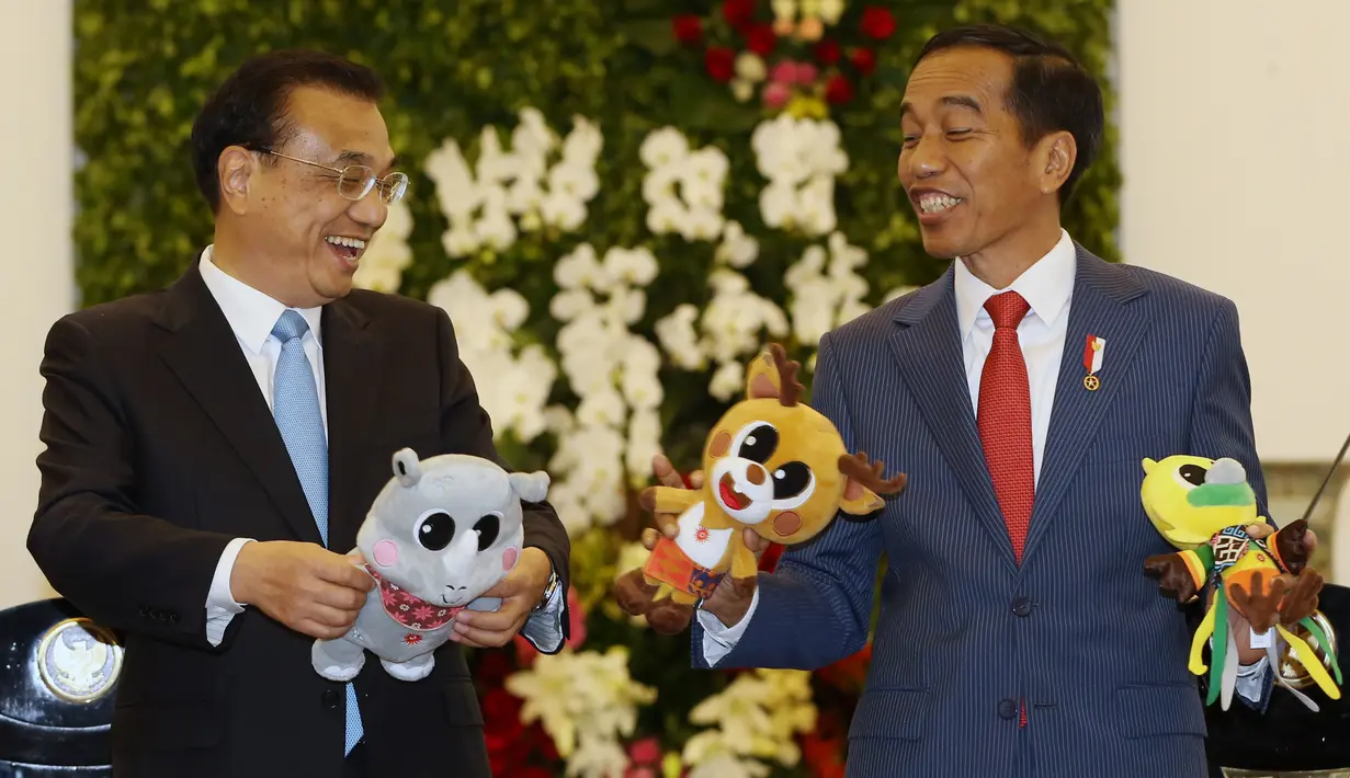 Presiden Jokowi berbincang dengan PM China Li Keqiang sambil memegang maskot Asian Games 2018 di Istana Bogor (7/5). (AFP/Pool/Dita Alangkara)