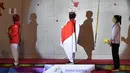 Peraih medali emas Indonesia Susanti Rahayu Aries (tengah), medali perak Puji Lestari dan perunggu He Cuilian mendengarkan lagu Indonesia Raya pada upacara medali olahraga panjat tebing wanita Asian Games 2018 di Palembang (23/8). (AFP PHOTO / Adek Berry)
