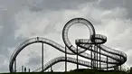 Orang-orang berjalan di sebuah instalasi tangga melingkar "Tiger and Turtle" di Duisburg, Jerman, 30 April 2018. Instalasi seni ini adalah patung jalan setapak menyerupai roller coaster yang berada di atas puncak bukit. (AP/Martin Meissner)