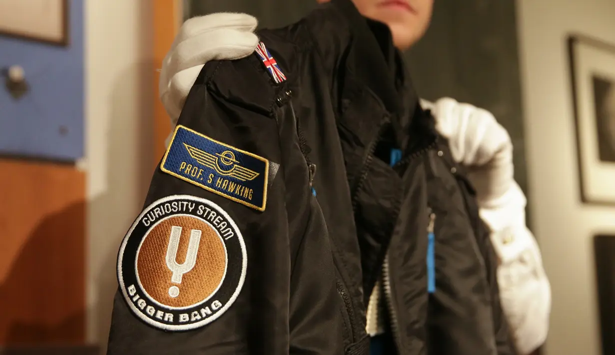 Seorang karyawan galeri berpose dengan jaket bomber yang digunakan saat pembuatan film dokumenter Stephen Hawking selama sesi pemotretan untuk acara pelelangan di Balai Lelang Christie, London, Selasa (30/10). (Daniel LEAL-OLIVAS/AFP)