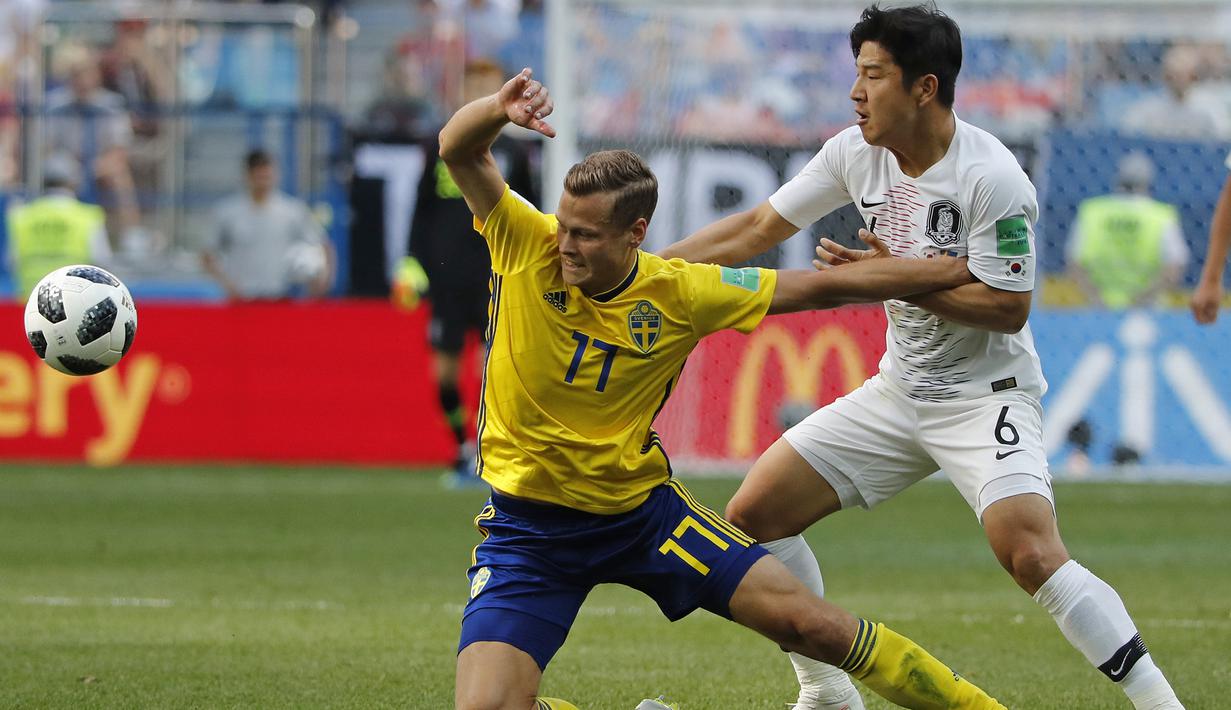 Pemain Swedia, Viktor Claesson (kiri) berebut bola dengan pemain Korea Selatan, Park Joo-ho pada laga grup E Piala Dunia 2018 di Nizhny Novgorod stadium, Nizhny Novgorod, Rusia, (18/6/2018). Swedia menang 1-0. (AP/Pavel Golovkin)