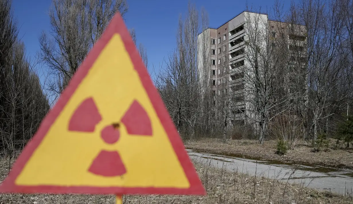 Plang nuklir terlihat di depan gedung kosong yang tidak di tinggali di kota Pripyat yang ditinggalkan penduduknya, dekat pembangkit tenaga nuklir, Ukraina, 28 Maret 2016. (REUTERS/Gleb Garanich)