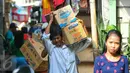 Warga memanggul kardus berisi barang miliknya di kawasan Pasar Ikan, Penjaringan, Jakarta, Rabu (6/4). Pemprov DKI telah mengeluarkan SP2 kepada warga Pasar Ikan untuk segera mengosongkan dan meninggalkan kawasan itu. (Liputan6.com/Yoppy Renato)