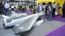 Pengunjung terlihat di samping model drone UAV Flying Eagle H3200 di stan Micro Multi Copter (MMC) selama Drone World Congress (DWC) di Shenzhen pada 21 Mei 2026. (HECTOR RETAMAL/AFP)