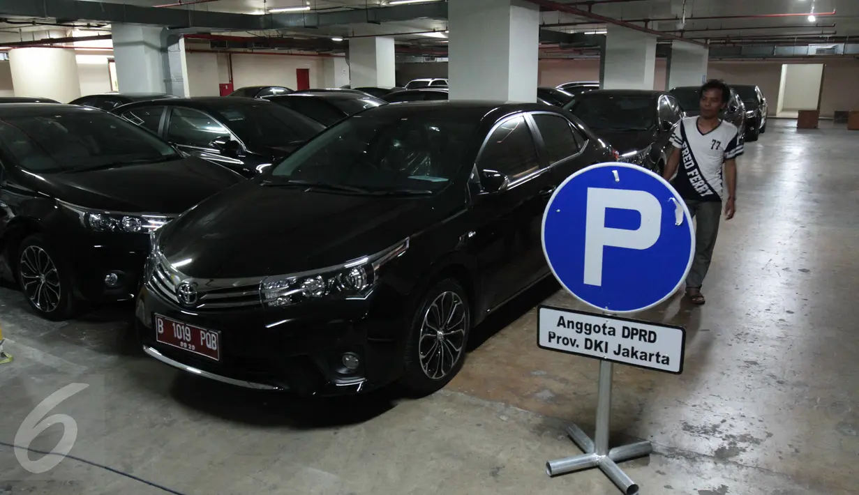 Seorang pria berjalan di dekat mobil sedan Toyota Corolla Altis di basement Gedung DPRD DKI Jakarta, Kamis (3/9). Mobil tersebut dibelikan Gubernur Basuki ‘Ahok’ Tjahaja Purnama untuk 101 anggota DPRD DKI periode 2014-2019. (Liputan6.com/Gempur M Surya)