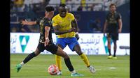 Pemain Al Nassr, Sadio Mane (kanan), berusaha melewati hadangan pemain Al Taawon dalam laga pekan ke-2 Liga Arab Saudi 2023/2024 yang berlangsung di KSU Football Stadium, Sabtu (19/8/2023) dini hari WIB. (AFP/Fayez Nureldine)