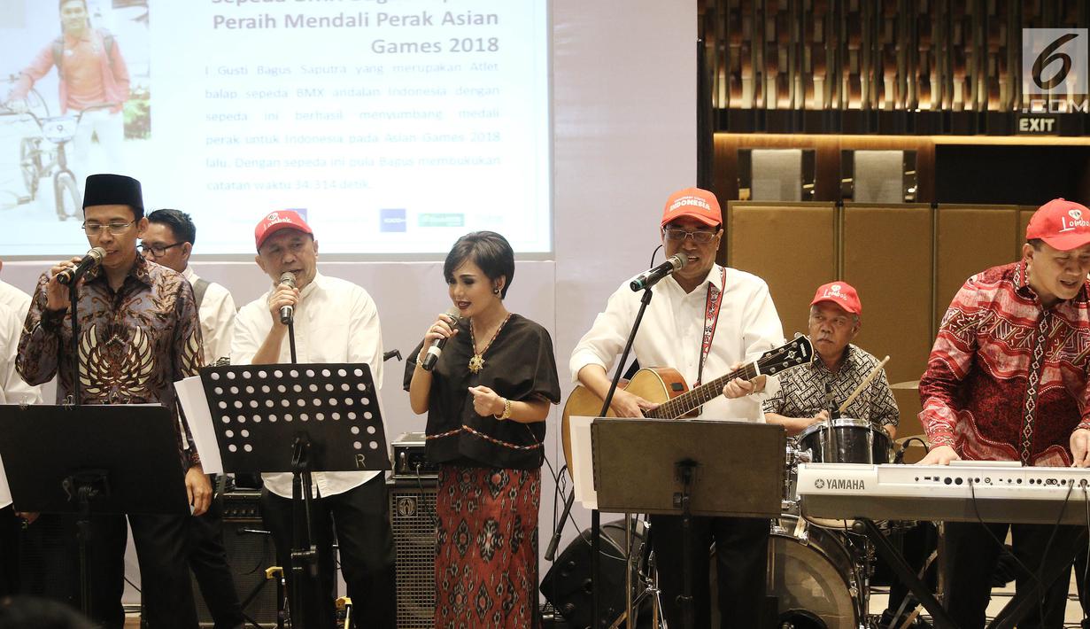 Gubernur NTB, TGB Muhammad Zainul Majdi saat tampil bersama dengan grup band Elek Yo Band  pada acara penggalangan dana untuk Lombok-Sumbawa dan peluncuran buku TGBNomics di Jakarta, Jumat (14/9). (Liputan6.com/Herman Zakharia)