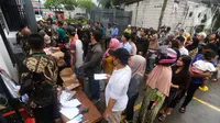 Warga antre untuk melakukan pencoblosan kertas suara pada ruang Pos Satpam di TPS 86 yang terpaksa dipindahkan di Duri Kepa, Jakarta Barat, Rabu (14/2/2024). (merdeka.com/Arie Basuki)