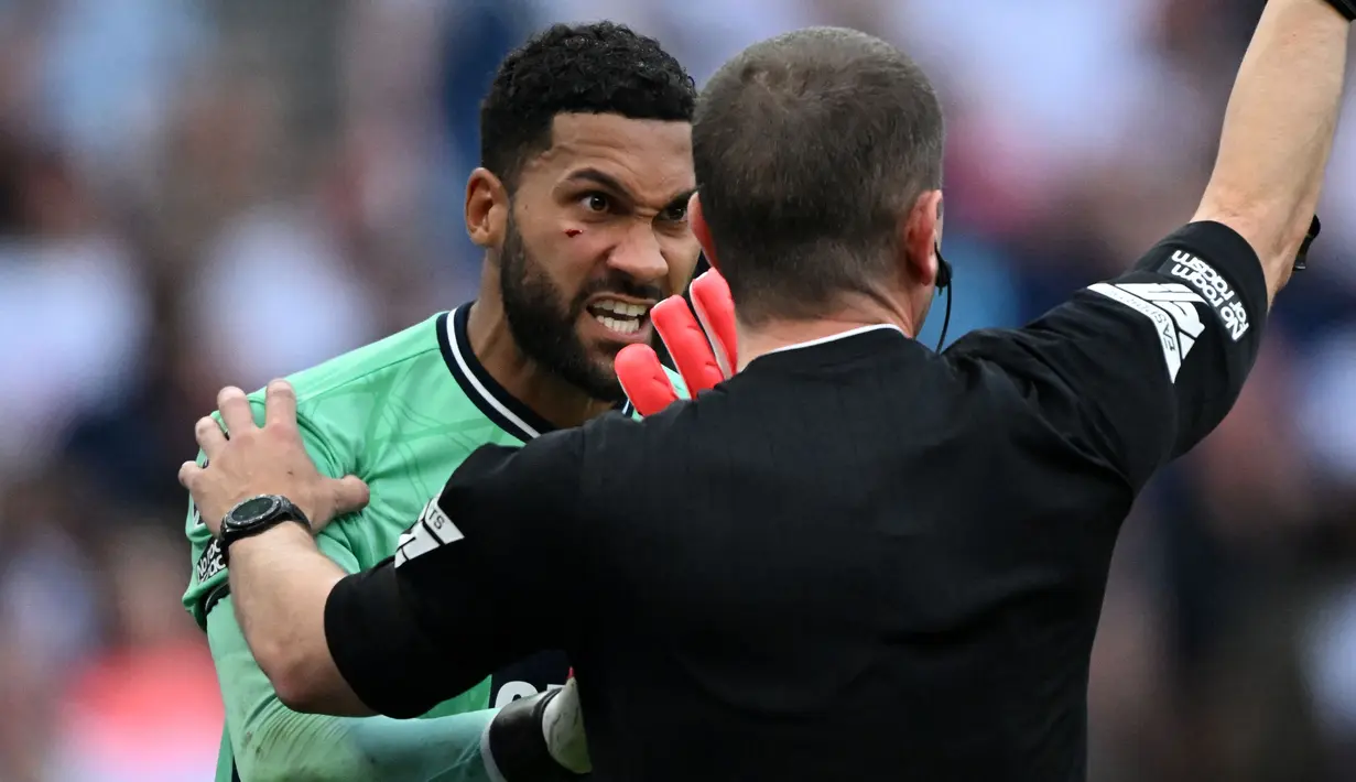 Wasit Peter Bankes memberi kode kepada tim medis untuk memberi perawatan kepada kiper Sheffield United, Wes Foderingham yang mengalami cedera di bagian wajah saat menghadapi Totttenham Hotspur pada laga pekan kelima Premier League 2023/2024 di Tottenham Hotspur Stadium, London, Sabtu (16/9/2023) malam WIB. (AFP/Justin Tallis)