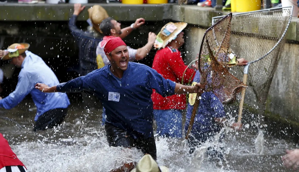 Seorang Nelayan bergembira usai mendapatkan ikan saat hari nelayan di Memmingen, Jerman, Sabtu (25/7/2015). Peserta yang menangkap ikan terbesar akan diberi nama "Raja Nelayan" selama satu tahun. (REUTERS/Michaela Rehle)