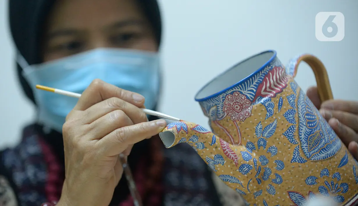 Perajin batik lukis ketel Nova Muhidir menyelesaikan lukisan batik di Studio Daroolang, Bintara, Tangerang Selatan, Banten, Rabu (2/12/2020). Lukisan ketel batik jadul khas nusantara di teko tempat air minum tersebut dijual dengan harga Rp 150 ribu hingga Rp 2,5 juta. (merdeka.com/Dwi Narwoko)