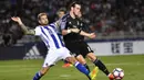 Pemain Real Madrid, Gareth Bale, berusaha melewati pemain Real Sociedad, Inigo Martinez. Bale berhasil mencetak dua gol kemenangan Los Blancos yang dibukukannya pada menit ke-2 dan 90+4. (AP/Alvaro Barrientos)
