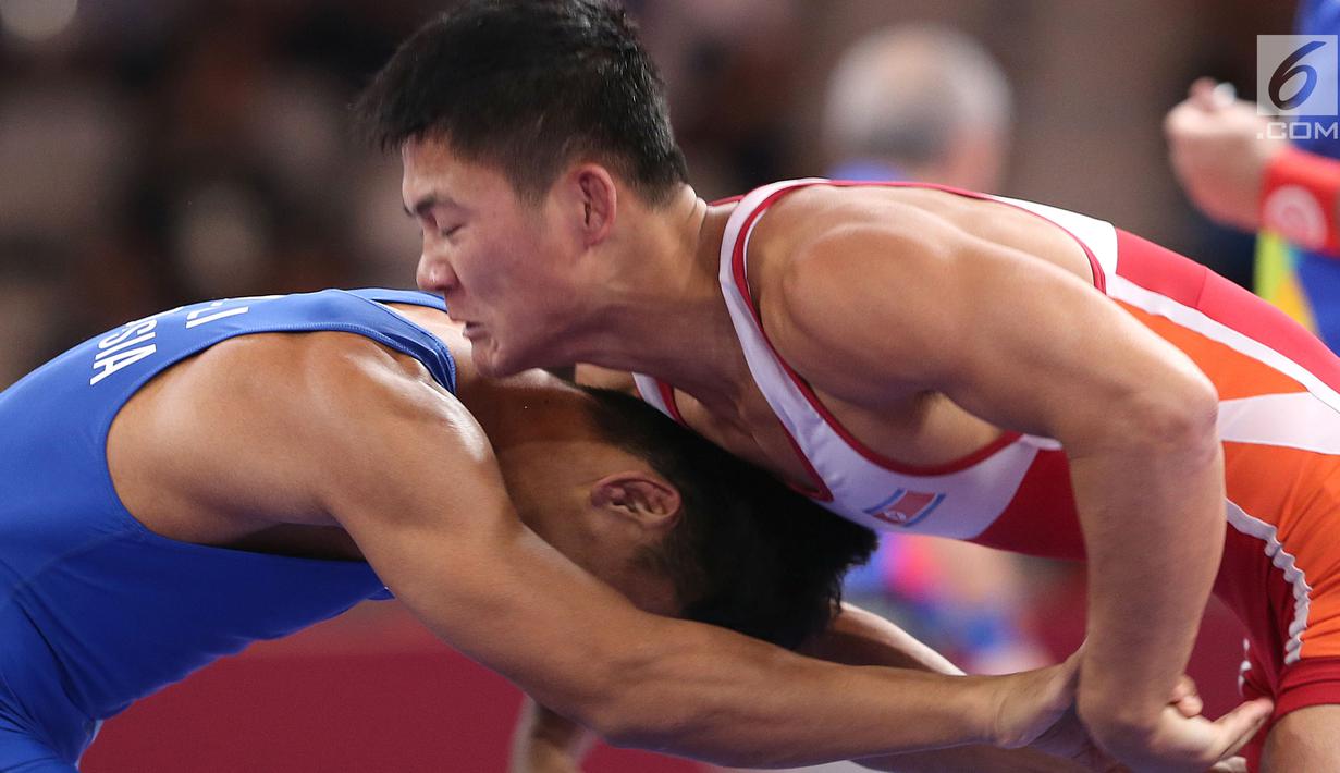 Pegulat putra Indonesia, Muhammad Aliansyah saat bertarung melawan pegulat Korea Utara Kim Myong Chol pada kelas putra 67 Kg di arena gulat JCC Senayan, Selasa (21/8). (Liputan6.com/Fery Pradolo)