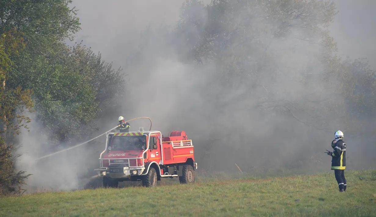 Petugas memadamkan api di hutan yang terbakar di Cissac-Medoc, Prancis, Kamis (21/4). Penyebab kebakaran masih dalam tahap penyelidikan. (PHOTO PHOTO / MEHDI FEDOUACH)