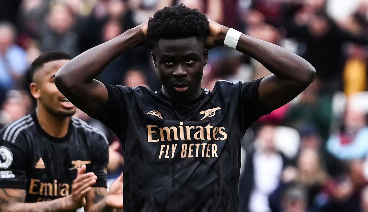 Reaksi kecewa gelandang Arsenal, Bukayo Saka setelah eksekusi penaltinya ke gawang West Ham United melebar dan gagal berbuah gol pada laga pekan ke-31 Liga Inggris 2022/2023 di London Stadium, London (17/4/2023). (AFP/Ben Stansall)