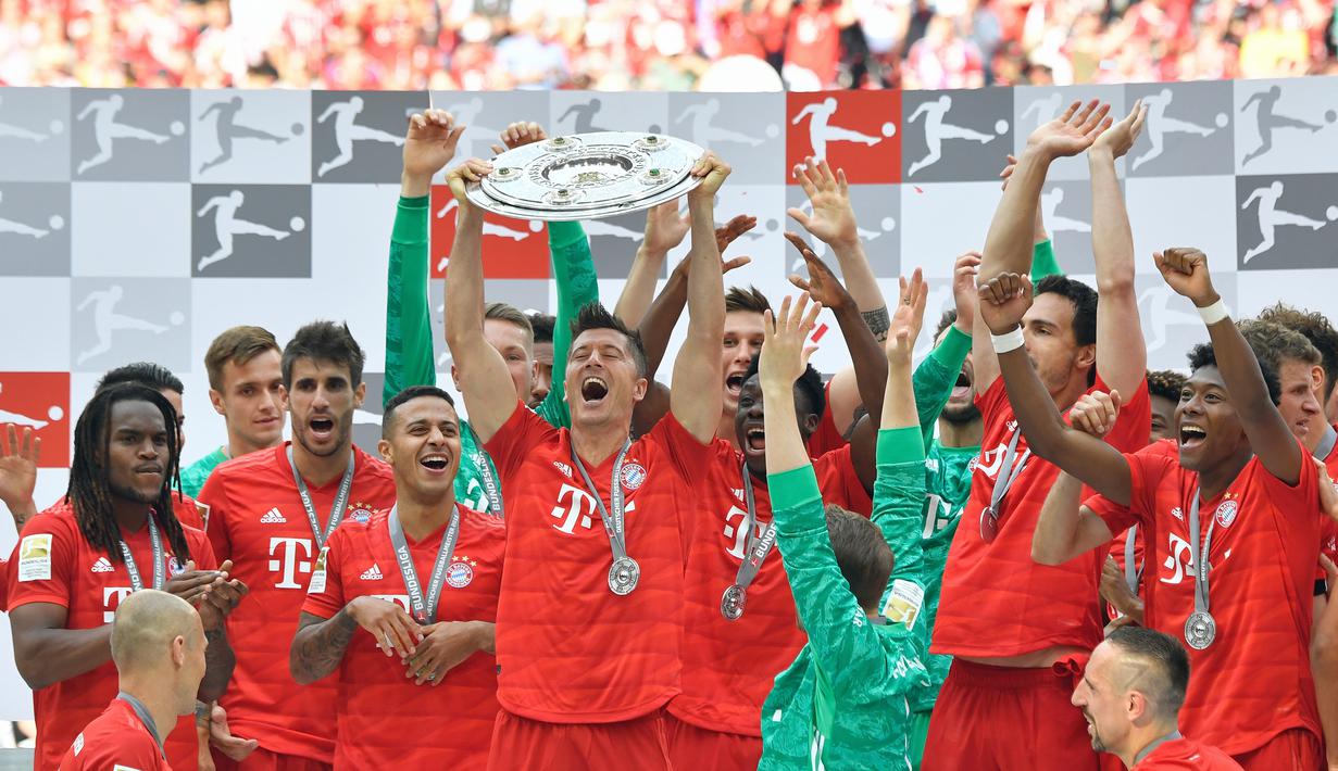 Pemain Bayern Munchen, Robert Lewandowsk, mengangkat trofi Bundesliga usai mengalahkan Frankfurt di Allianz Arena, Jerman, Sabtu (18/5). Munchen menang 5-1 atas Frankfurt. (John Macdougall/AFP)