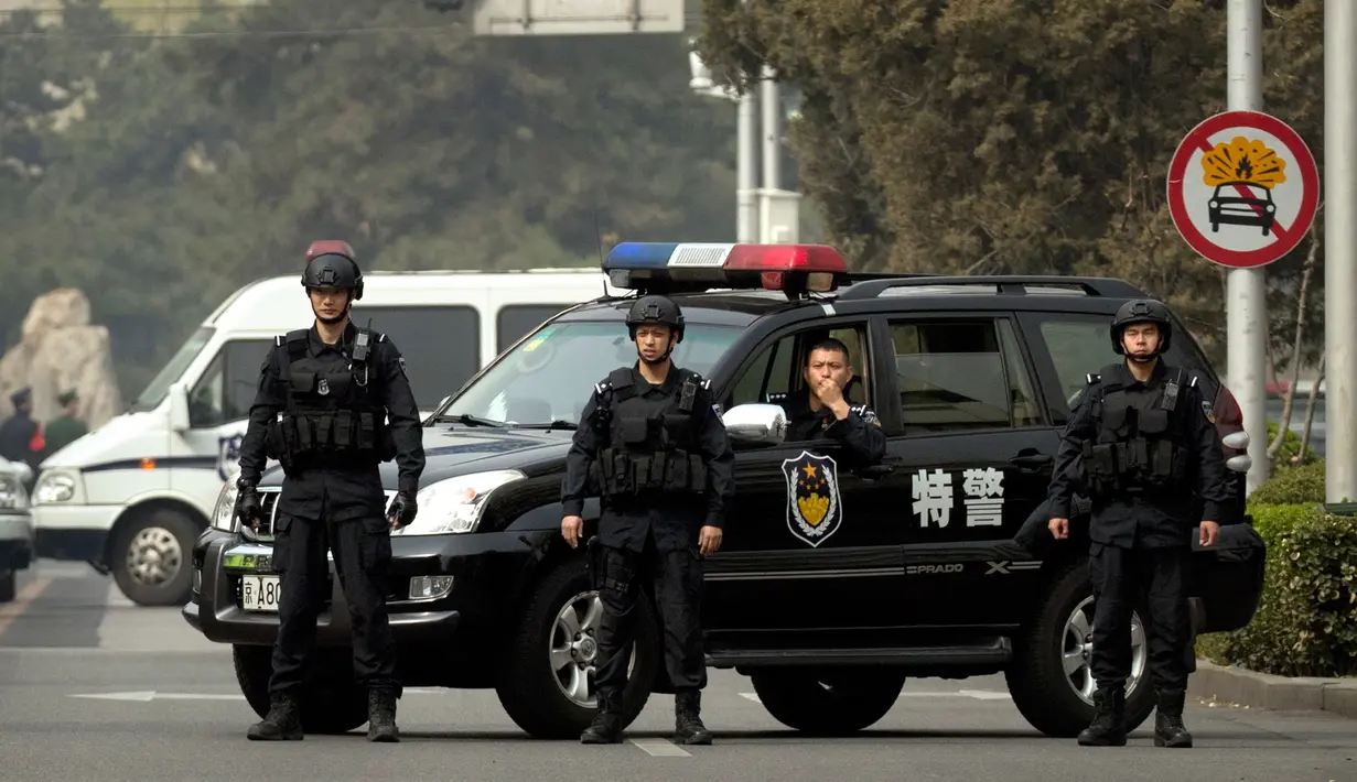 Polisi dengan peralatan taktis memblokir jalan menuju Wisma Negara Diaoyutai, Beijing, Selasa (27/3). Wisma tersebut biasa menjadi tempat menginap para pejabat asing. (AP Photo/Mark Schiefelbein)