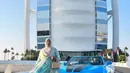 Bak crazy rich Dubai, Tasyi berpose di hotel bintang 7, Burj Al Arab dalam balutan abaya biru muda dengan detail motif keemasan, dilengkapi tas Prada galleria satin with crystal. @tasyiiathasyia.