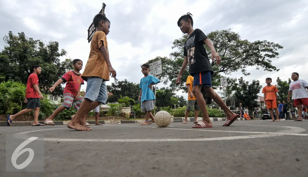 Sejumlah anak bermain sepak bola di Jalan Tambak, Manggarai, Jakarta, Jumat (22/7). Masih kurangnya taman bermain di Jakarta, membuat warga khususnya anak-anak memanfaatkan fasilitas yang bukan peruntukannya. (Liputan6.com/Yoppy Renato)