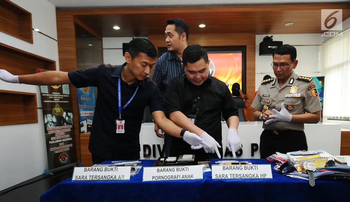 Petugas mengecek barang bukti kejahatan melalui internet saat rilis di Mabes Polri, Jakarta, Selasa (30/5). Petugas menahan enam tersangka dari empat kasus berbeda. (Liputan6.com/Helmi Fithriansyah)