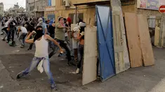 Warga Palestina melempar batu ke arah polisi Israel dalam bentrokan di Shuafat, sebuah daerah pinggiran Arab, Yerusalem, Senin (5/10/2015). Seorang remaja Palestina tewas pada Senin dalam bentrokan di Tepi Barat. (REUTERS/Ammar Awad)