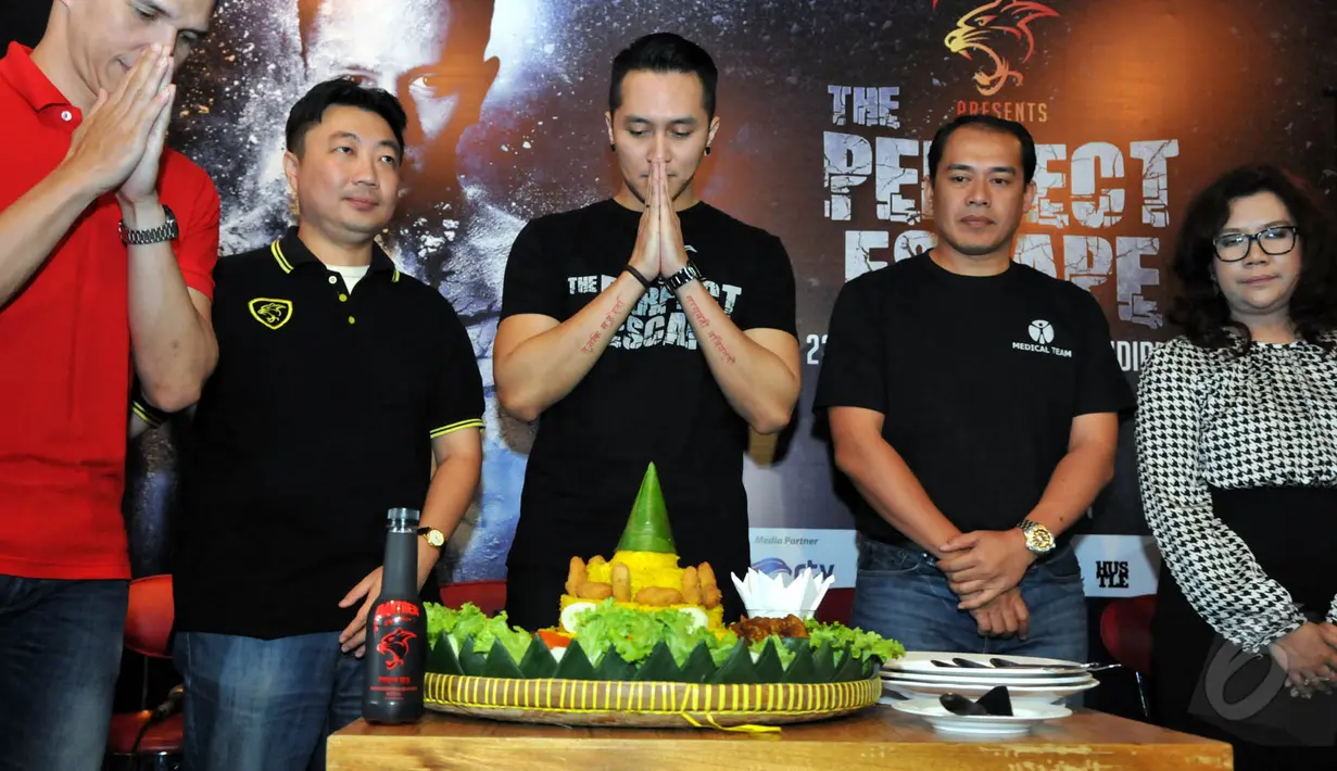 Demian (tengah) mengadakan ‘selametan’ usai konferensi pers terkait rencananya membuat aksi ekstrem, Jakarta, Rabu (20/5/2015). Demian berharap acaranya nanti berjalan dengan lancar. (Liputan6.com/Panji Diksana)