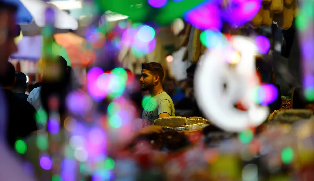 Pedagang menawarkan lentera Ramadan kepada pengunjung sebuah pasar di Kota Gaza, Kamis (25/5). Warga Palestina merayakan datangnya bulan puasa dengan memasang lentera tradisional khas Ramadan sebagai dekorasi rumah mereka. (AP Photo/Adel Hana)