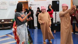 Kim Kardashian menyaksikan anak-anak menari saat kunjungannya di Rashid Media Centre, Dubai (16/1). Selama kunjungannya, Kim Kardashian menyaksikan sebuah film dokumenter tentang sejarah kota tersebut. (AFP Photo And Rashid Media Center/Stringer)