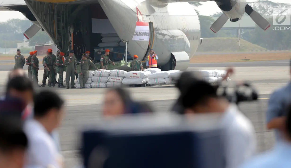 Prajurit TNI AU memasukkan bantuan kemanusiaan Rohingya ke dalam pesawat Hercules di Lanud Halim Perdanakusuma, Jakarta, Rabu (13/9). Sebanyak 34 ton bantuan itu berupa beras, bahan siap saji, tenda, dan selimut. (Liputan6.com/Faizal Fanani)