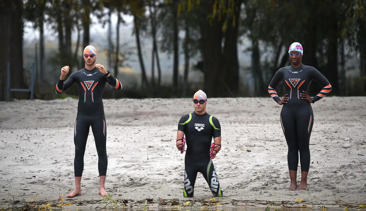 (kiri ke kanan) Mathieu Witvoet, petualang lingkungan, Theo Curin, perenang dengan amputasi empat anggota badan, dan Malia Metella, wakil juara Olimpiade gaya bebas 50m di Olimpiade Athena, berlatih di perairan terbuka pada air 12 derajat celcius, di Compiegne, 23 Oktober 2020. (FRANCK FIFE/AFP)