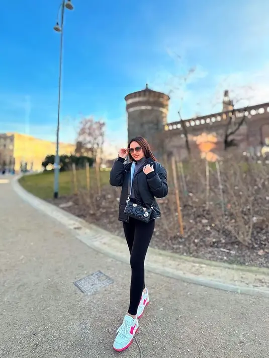 Ia juga tampil serba hitam dengan padding jaket dan celana ketat hitamnya. Dipadukan inner turtleneck abu-abu. Sambil membawa tas Dior hitam. [@happy_asmara77]