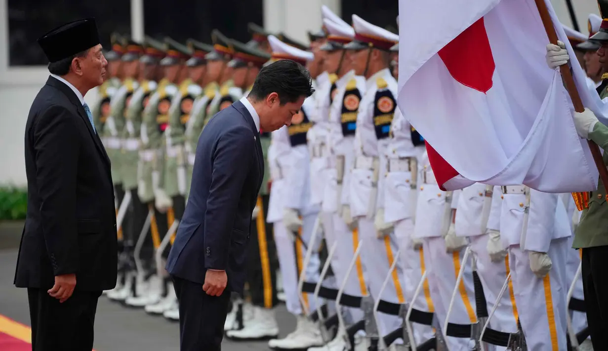 Penandatanganan tersebut merupakan bagian dari rangkaian Defence Minister Meeting 2026. Tampak dalam foto, Menteri Pertahanan Jepang Shinjiro Koizumi (tengah) membungkuk memberi hormat kepada bendera nasional Indonesia dan Jepang saat memeriksa barisan kehormatan bersama Menteri Pertahanan Republik Indonesia, Sjafrie Sjamsoeddin (kiri), selama upacara penyambutan di Jakarta, Senin 4 Mei 2026. (AP Photo/Achmad Ibrahim)