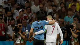 Penyerang Portugal, Cristiano Ronaldo memapah Penyerang Uruguay, Edinson Cavani yang Cedera keluar lapangan saat pertandingan babak 16 besar Piala Dunia 2018 di Stadion Fisht di Sochi, Rusia (30/6).  (AP Photo/Themba Hadebe)