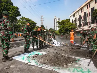 Personel Tentara Nasional Indonesia (TNI) dari unsur Kostrad dan Marinir membersihkan material sisa unjuk rasa di sekitar Simpang Pasar Senen, Jakarta, Minggu (31/8/2025). (merdeka.com/Arie Basuki)