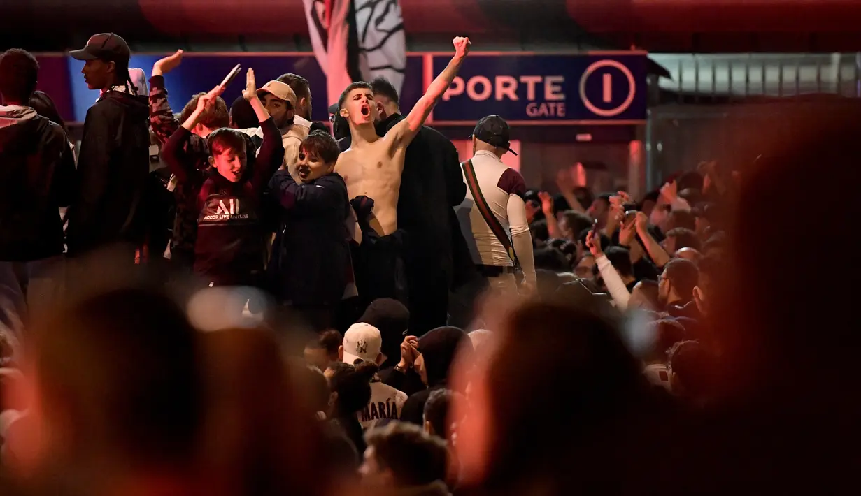 <p>Suporter Paris Saint-Germain (PSG) merayakan gelar Ligue 1 Prancis klub mereka pada akhir laga pekan ke-34 Ligue 1 kontra Lens di luar Parc des Princes, Minggu (24/4/2022) dini hari WIB. PSG juarai Liga Prancis untuk ke-10 kali meski ditahan seri Lens 1-1. (JULIEN DE ROSA / AFP)</p>
