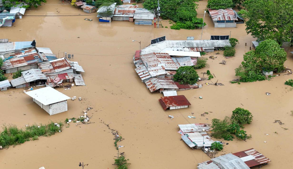 Sedikitnya dua orang dilaporkan tewas, sementara lebih dari satu juta warga telah dievakuasi dari jalur lintasan badai tersebut. Tampak foto udara menunjukkan pemandangan rumah-rumah yang terendam banjir di Kota Tuguegarao, Provinsi Cagayan, di utara Manila pada 10 November 2025, setelah sungai meluap akibat hujan deras yang disebabkan oleh Topan Super Fung-wong. (John DIMAIN/AFP)