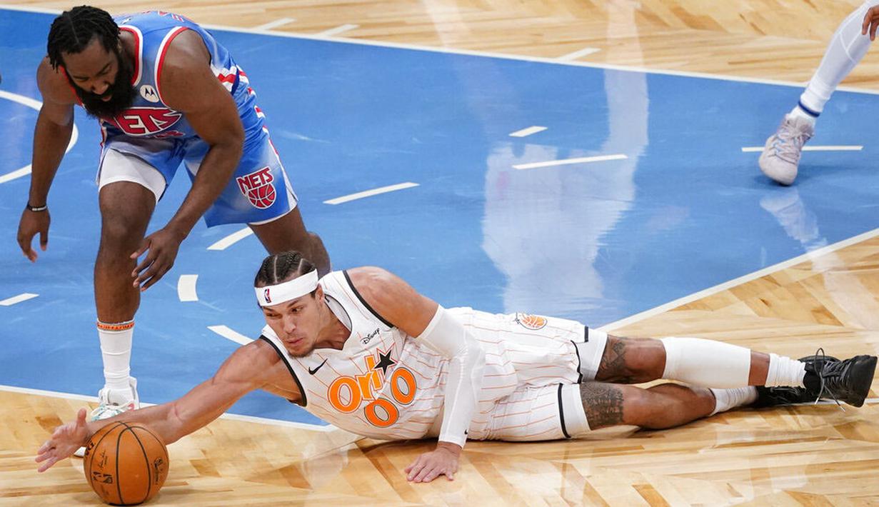 Pebasket Brooklyn Nets, James Harden, berebut bola dengan pebasket Orlando Magic, Aaron Gordon pada laga NBA, Sabtu (16/1/2021). Nets menang dengan skor 122-115. (AP Photo/Mary Altaffer)