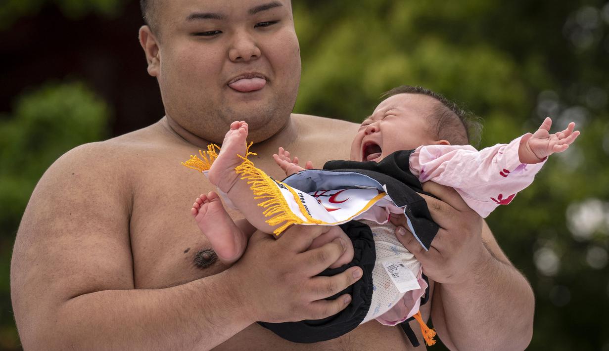 Sumo yang terkenal dengan olahraga gulat tradisional dari Negeri Sakura tersebut berubah menjadi ajang adu tangis para bayi. (AFP/Yuichi Yamazaki)