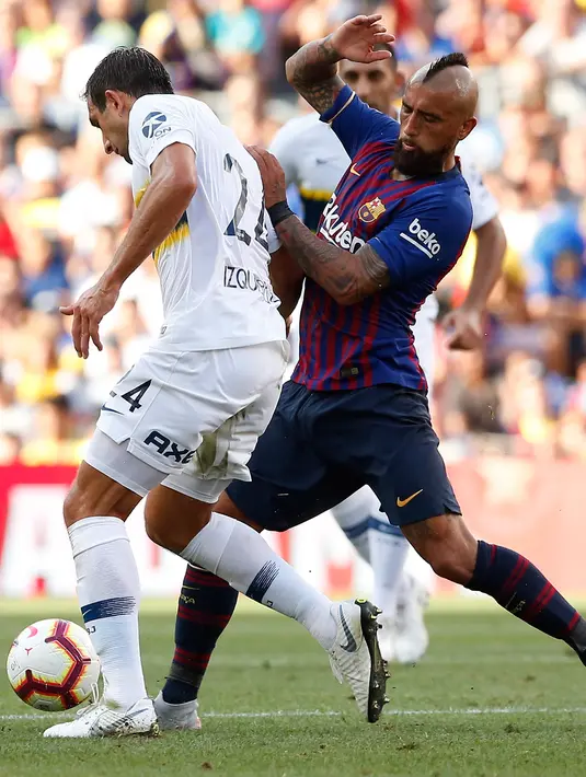 Gelandang Barcelona, Arturo Vidal berusaha merebut bola yang dibawa pemain Boca Juniors, Carlos Izquierdoz selama pertandingan Piala Joan Gamper di stadion Camp Nou, Spanyol (15/8). Barcelona menang telak 3-0 atas Boca Juniors. (AP Photo/Manu Fernandez)