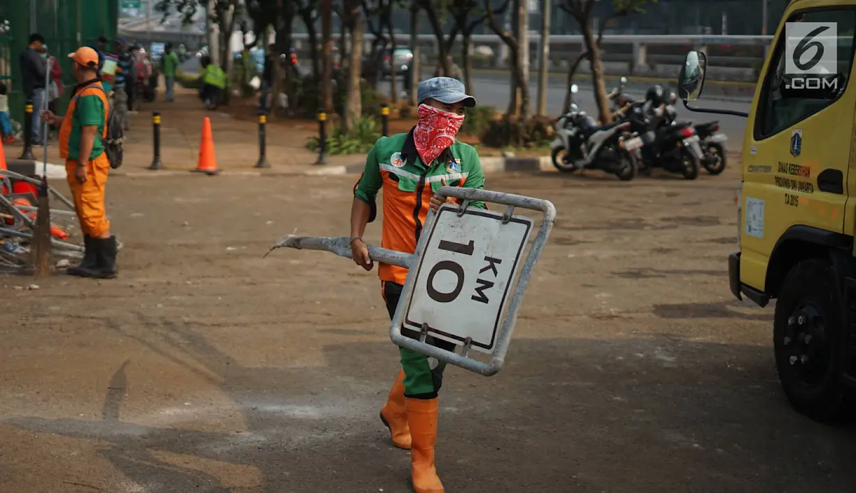 Petugas membersihkan sampah sisa bentrok antara mahasiswa dan polisi dalam unjuk rasa di depan Gedung DPR RI, Jakarta, Rabu (25/9/2019). Bentrokan pada Selasa (24/9/2019) menyisakan sampah yang memenuhi kawasan di sekitar Gedung DPR. (Liputan6.com/Immanuel Antonius)