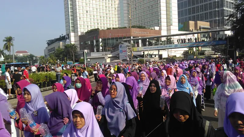 Ratusan orang membagikan hijab gratis di kawasan car free day Bundaran Hotel Indonesia (HI), Jakarta.